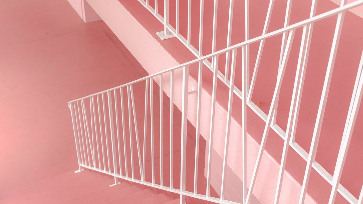 White railings crossing pink stairways and landings.