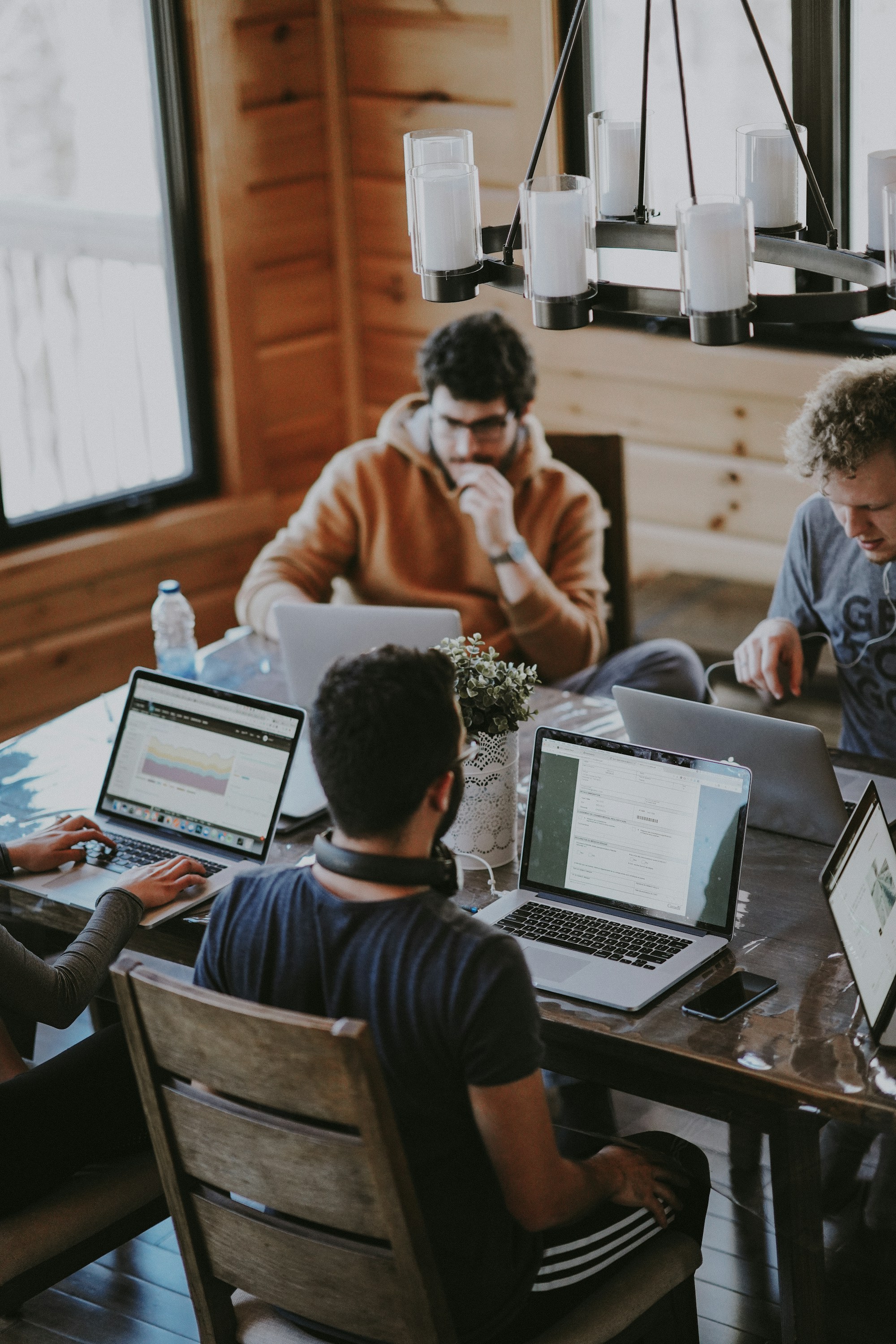 People working together around a table with their laptops.